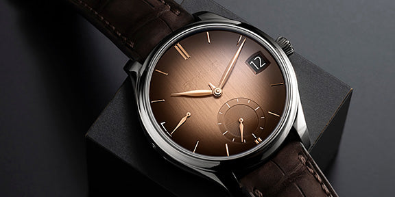 Moser Watch with brown leather strap and brown dial on a dark background