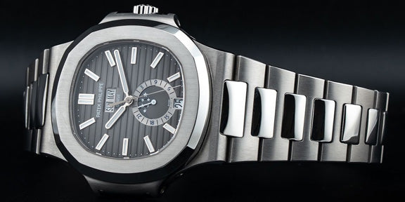 Silver watch with a detailed face on a black background